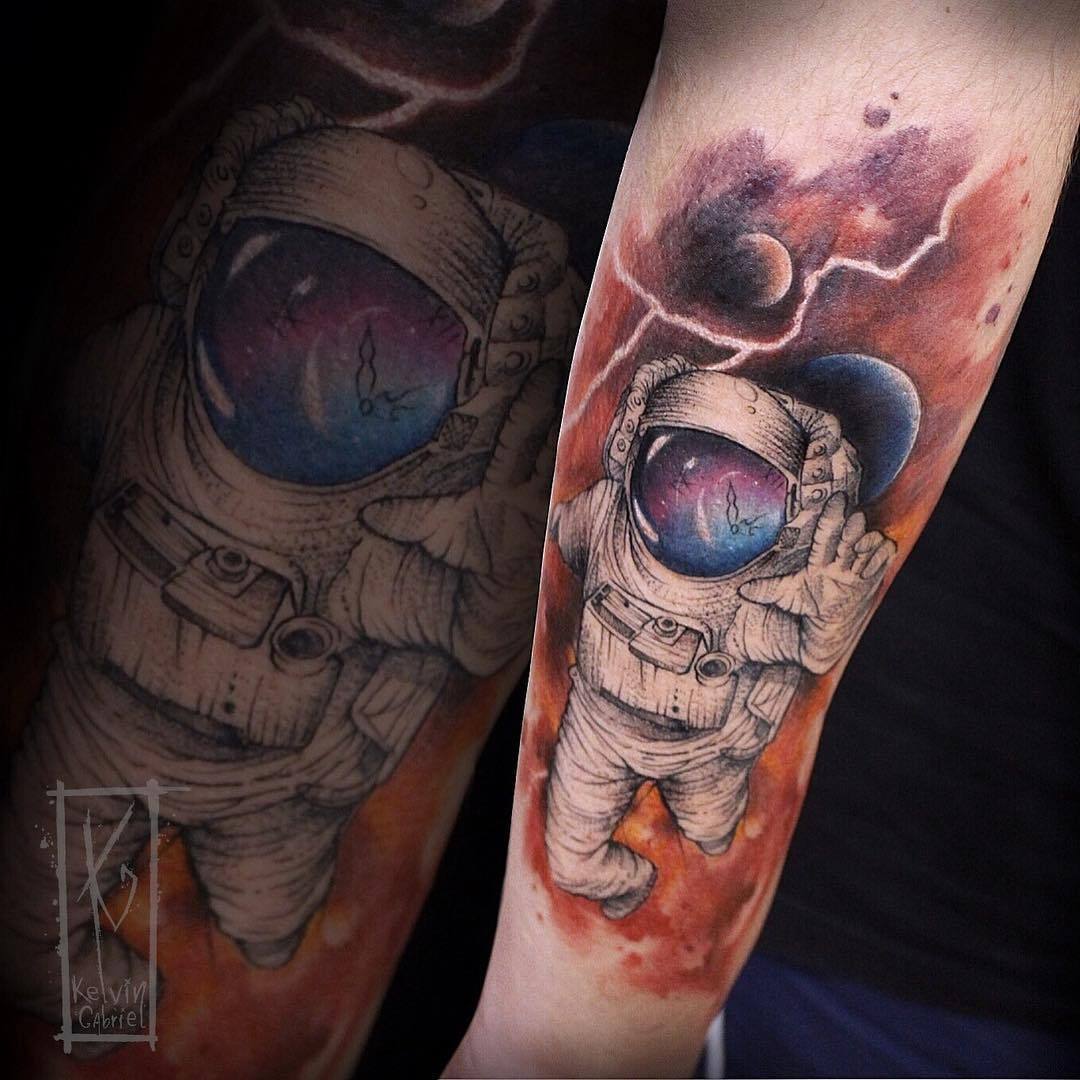 Colored astronaut with universe tattoo on lower sleeve