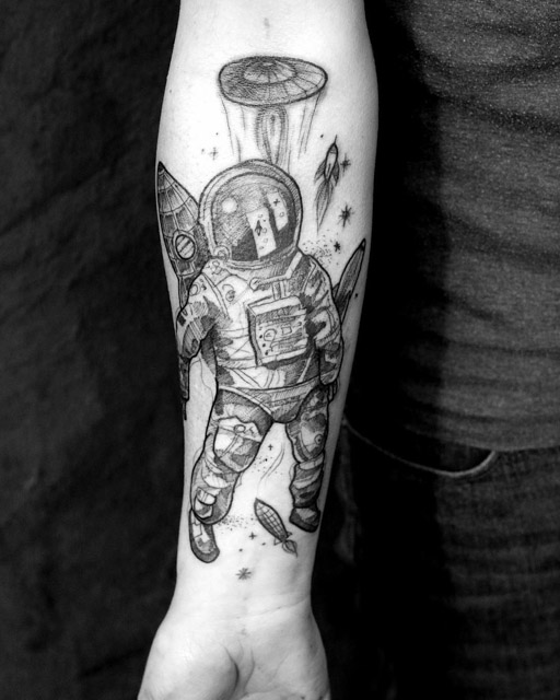 Grey shaded astronaut tattoo on inner forearm by Martynas Snioka