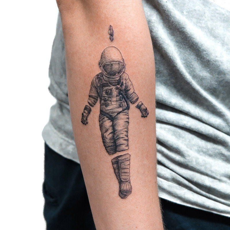 Grey shaded astronaut tattoo on inner forearm by sameoldkid