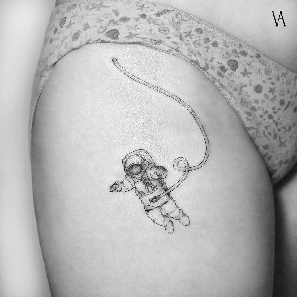 Grey shaded astronaut tattoo on upper thigh