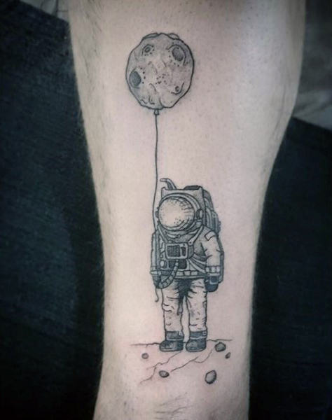 Grey shaded astronaut with crater on string tattoo on inner sleeve