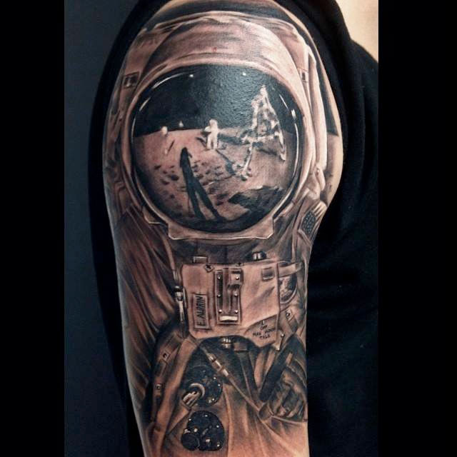 Grey shaded astronaut with reflection tattoo on upper arm