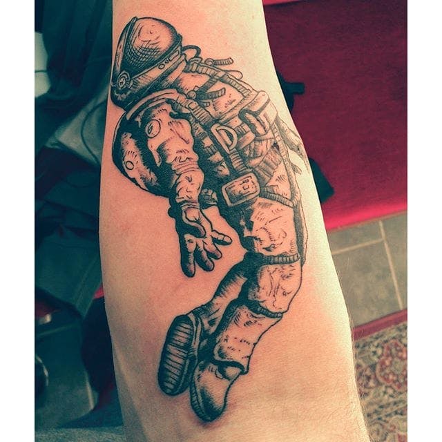 Grey shaded floating astronaut tattoo on body